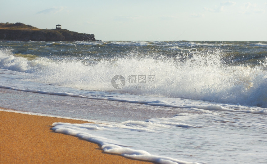 海浪在岸线和斗蓬外冲浪远处有馆图片