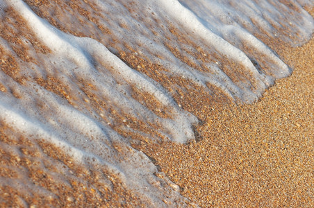 金色海岸线沙砂上的冲浪泡沫图片