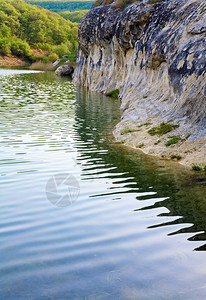美丽的湖泊在水面上有泉岩层反射图片