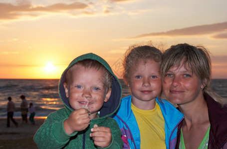 在沙海滨岸上与母亲和小女孩男的母亲图片