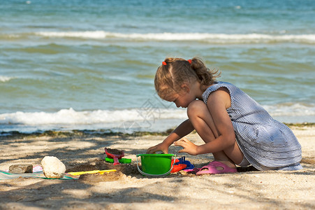 小女孩在海边玩沙子图片