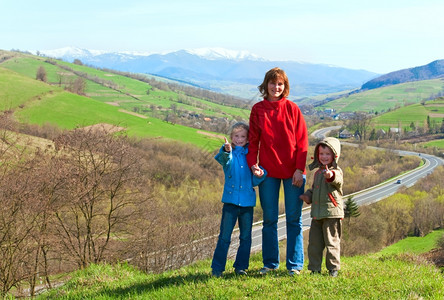 旅游家庭和春季山区乡村谷与农田和公路图片