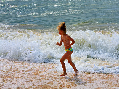 小女孩在海滩上玩冲浪游戏图片