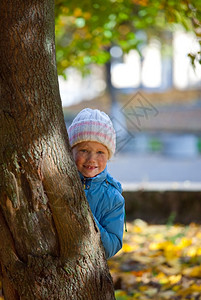 小女孩躲在大树后图片