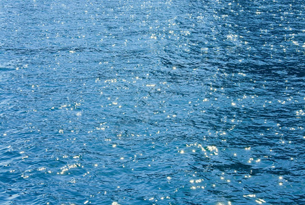 带波浪和太阳反射的浅海水表面图片