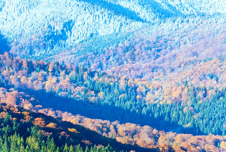 阳光秋天的山林和第一个秋天的霜冻在树顶山边的上图片