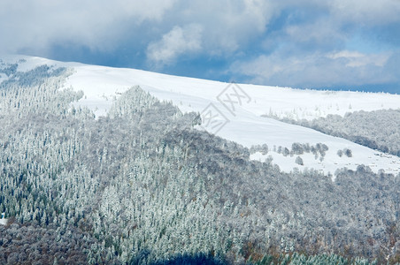 十月的山景第一次冬季雪和去年秋天的多彩叶子在遥远的山边图片