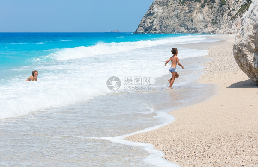 两个儿童在靠近爱奥尼亚海EgremniLefkada希腊的AzureIonian海EgremniLefkada附近的白沙滩上有以图片