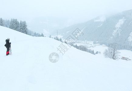 温冬的山雾枯燥白日雪风的景和散步女子图片