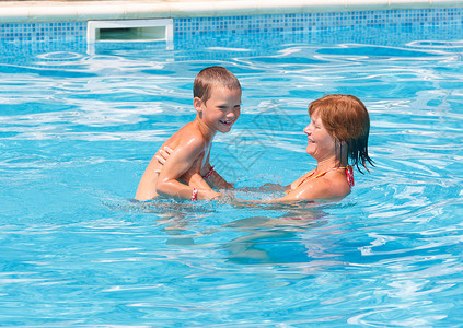 妈和她儿子在暑期户外游泳池图片