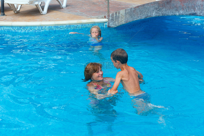 母亲训练孩子们在游泳池图片