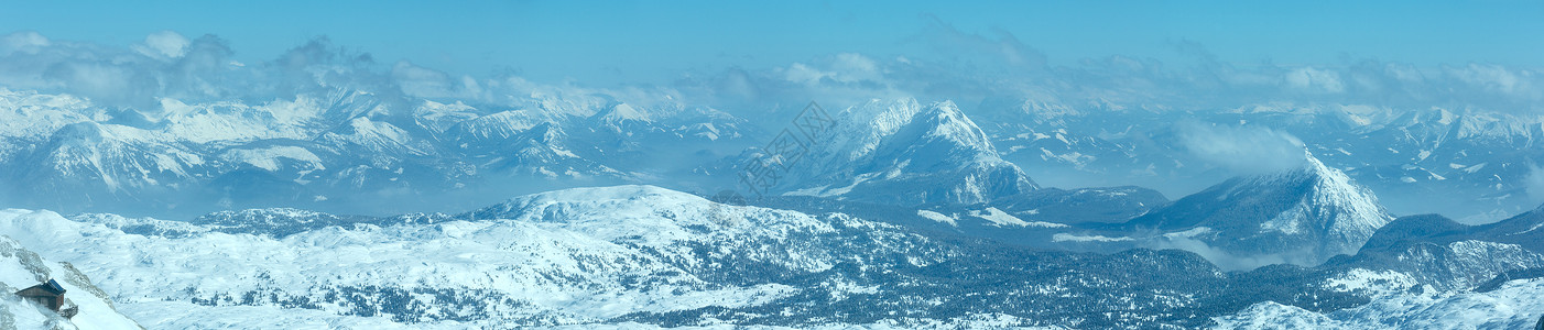 Dachstein山顶和岩石坡上的房屋奥地利的冬季风景图片