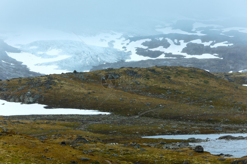 带湖泊和雪的浓雾夏季山地景观挪威不远的尼加德斯布林冰川图片