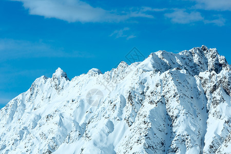 清晨冬天雪岩顶端阳光明媚的风景图片