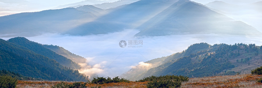 秋天清晨的山景与太阳光和烟雾图片