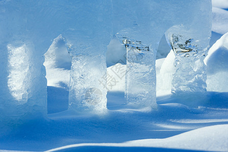 春天的阳光照亮了雪上透明的冰柱背景图片