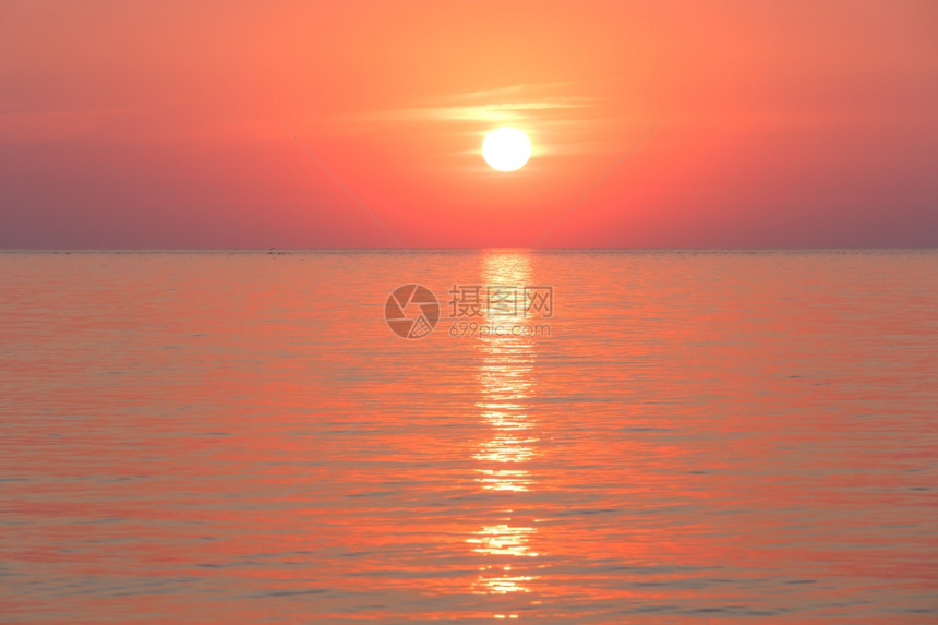 美丽的迷人清晨海景与日出和太阳轨道在表面图片