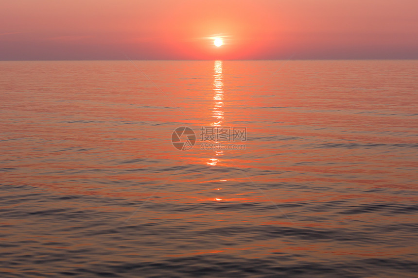 美丽的迷人清晨海景与日出和太阳轨道在表面图片