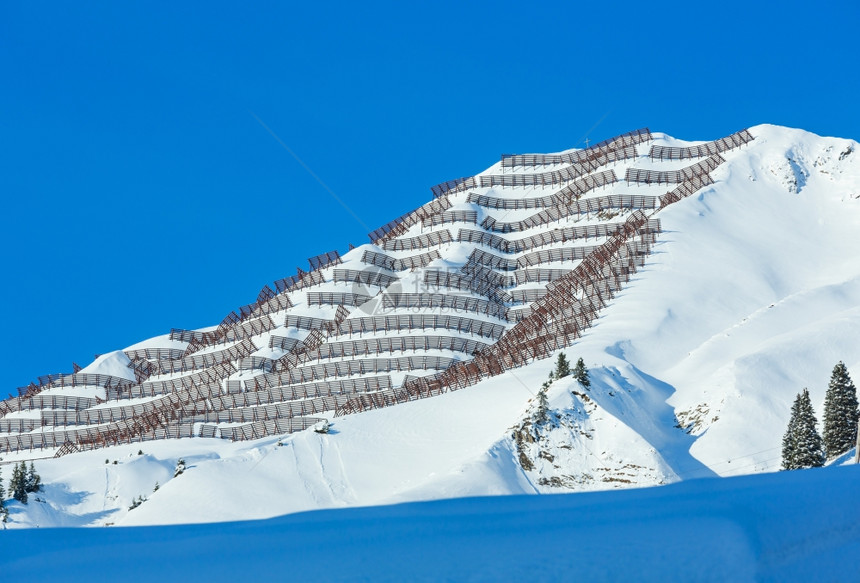冬山坡上有雪壁和金属的屏障图片