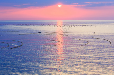 美极了的清晨海景日出面和渔网的太阳足迹船上的人是无法辨认图片