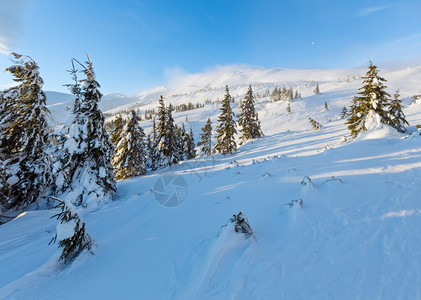 上午冬季山区风景坡上有云和木林喀尔巴阡山图片