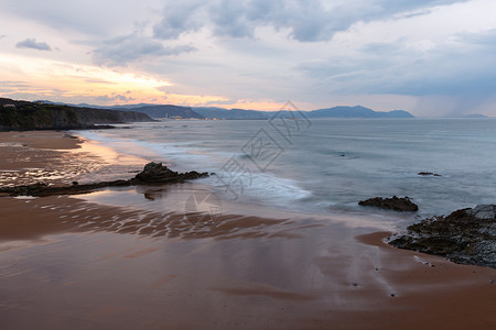黄昏的海洋岩石岸风景天空反射在沙滩湿上西班牙高清图片