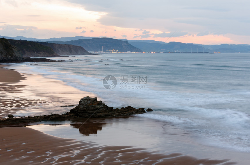 黄昏的海洋岩石岸风景天空反射在沙滩湿上西班牙图片