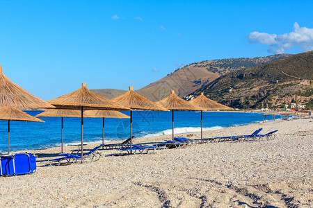 沙滩夏季清晨带防晒床和草荫遮阳剂阿尔巴尼亚博什图片