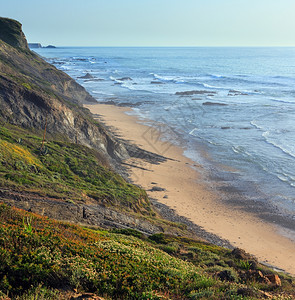 夏季傍晚的洋景和低潮时地盘海滩AljezurAlgarve葡萄牙图片