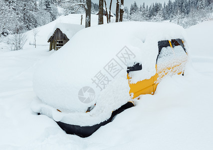 黄色车在冬季斜坡的雪下漂流图片