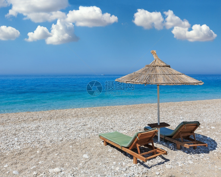 夏晨沙滩有防晒床和草荫的遮阳阿尔巴尼亚深蓝天空有积云图片