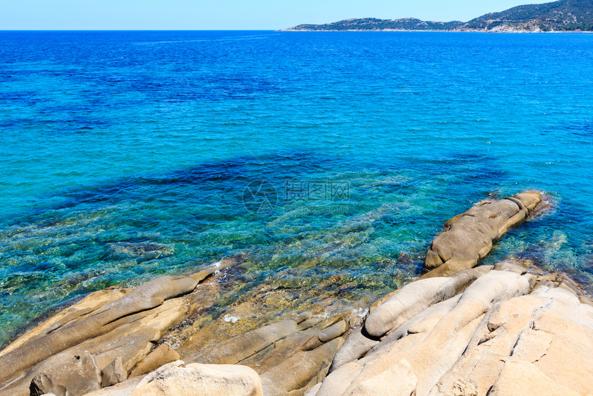 夏季海洋景色与平面透明的水从岸上查看西图尼亚哈尔基迪希腊图片