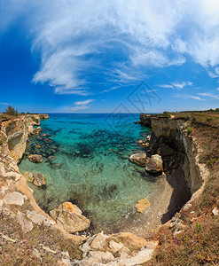 恩普莱多意大利普亚萨顿海岸TorreSantAndrea的悬崖岩石拱门和堆叠物faraglioni背景