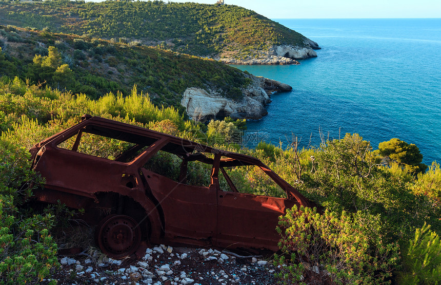 意大利普亚Gargano半岛SanFeliceArch附近夏季海岸山丘上破碎的烂生锈汽车图片