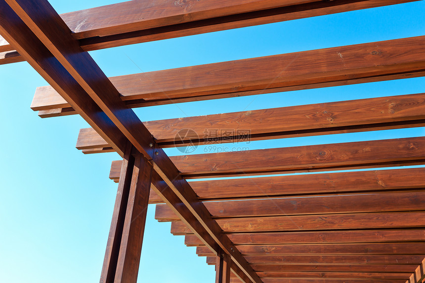 在蓝天空背景的瞪羚上部分木制屋顶结构图片
