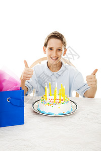 可爱的小男孩在生日派对上举起拇指白种背景图片