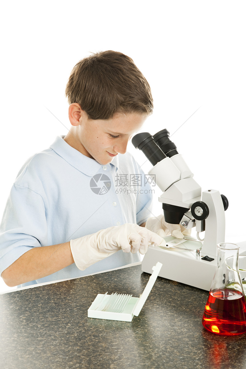上科学课的年轻男生透过显微镜看孤立在白色上图片