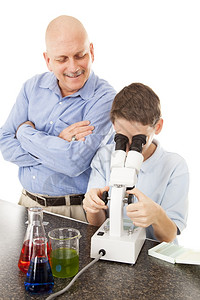 科学老师用显微镜观察年轻学生的垂直视角聚焦于学生白色背景图片