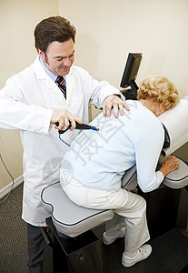 Chiroprator使用远程工具和计算机诊断调整病人脊椎对齐图片