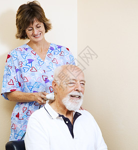老人从一个使用超声波机的按摩师护士那里得到止痛治疗图片