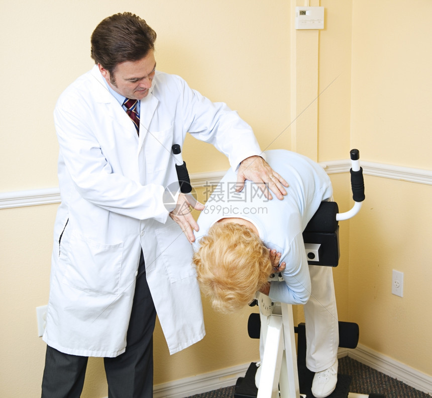 儿科医生帮助一位从背部受伤中康复的老年病人图片