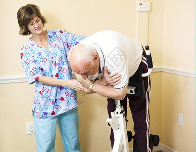 理疗师在按摩办公室帮助病人把脊椎伸展到罗马椅子上图片