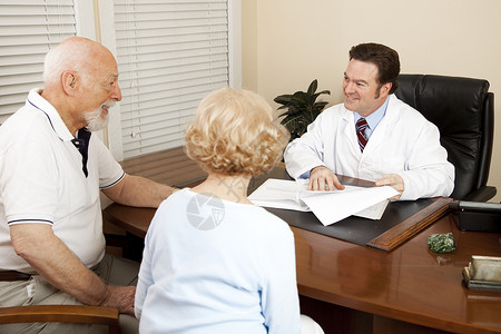 医生和他办公室的一对老年夫妇讨论治疗方案图片
