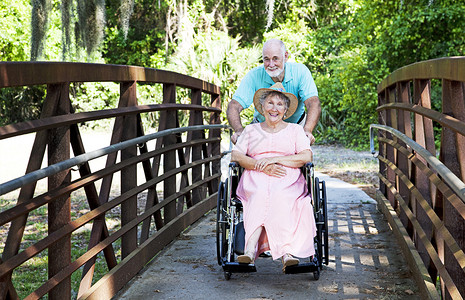 老人用轮椅将残疾妻子推过公园图片