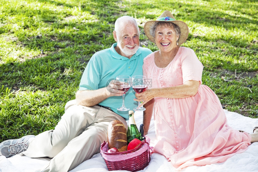 美丽的老夫妇在公园里有个浪漫的野餐图片