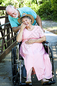 老年男子在轮椅上照顾残疾妻子图片