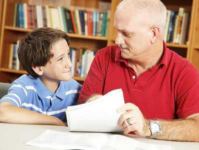学校男孩用怀疑的表达方式听老师或父亲的话背景图片
