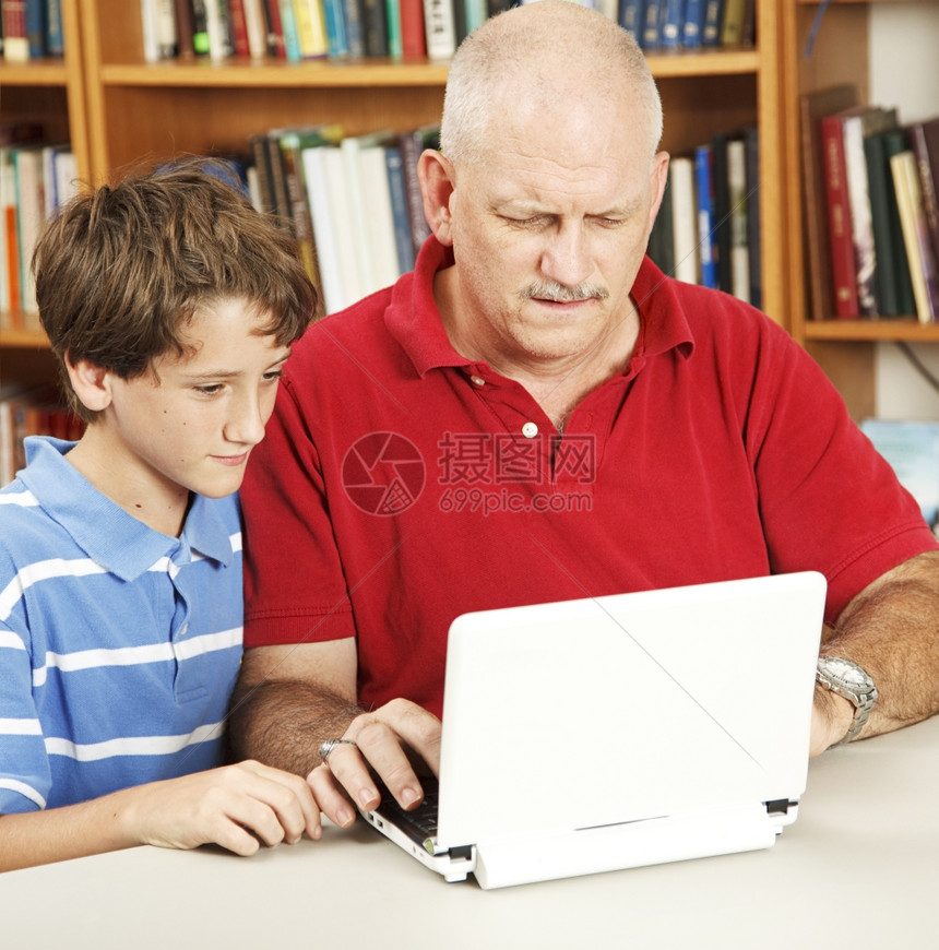困惑的父亲试图帮助他的儿子在网上电脑做功课图片