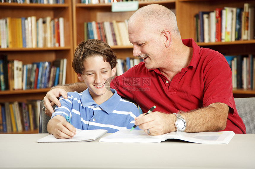 父亲在学校图书馆协助他儿子的功课图片
