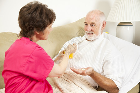 家庭保健护士给一位年长的病人果汁图片